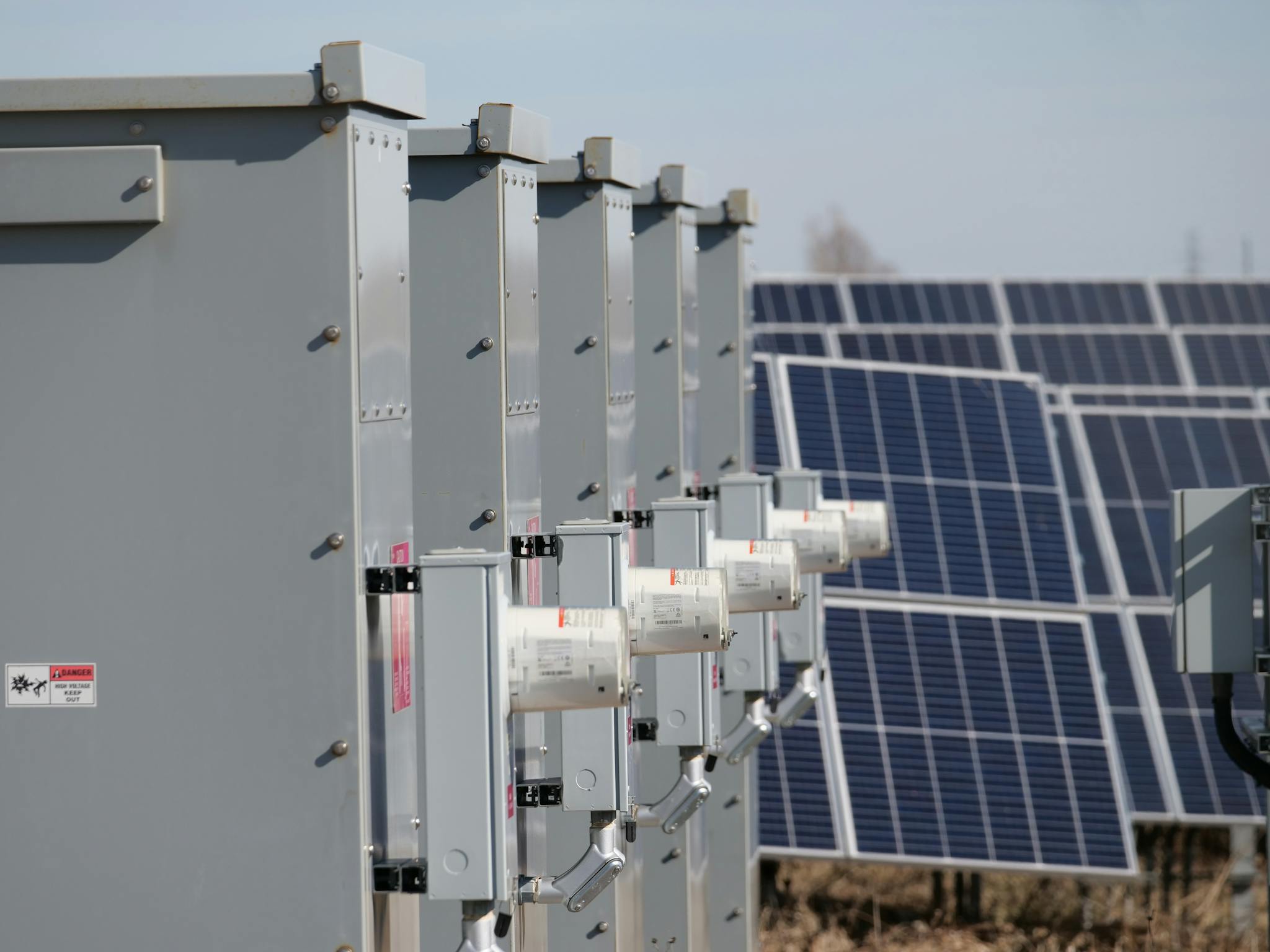 Close-up of electrical boxes and solar panels harnessing solar energy outdoors.